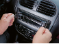Muškarac instalira auto-radio u kontrolnu tablu automobila.
