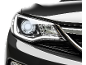 Prednje svetlo modernog automobila sa upaljenim LED svetlima, na crnoj pozadini.