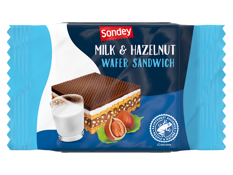 Mlečni i lešnik vafl sendvič sa slojem čokolade, čašom mleka i lešnicima.
