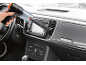 Ručni usisivač čisti unutrašnjost automobila, vidljiva kontrolna tabla i radio.