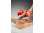Crvena paprika seče se u vazduhu sa prskanjem vode iznad drvene daske za sečenje.
