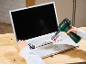 Akumulatorski duvač čisti tastaturu laptopa, sa viljuškom u drugoj ruci.