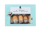 Kutija kokosovih petit four kolača sa filom od kajsije, delimično umočenih u čokoladu.