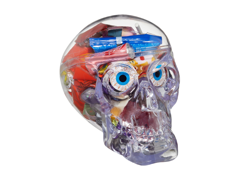 Providna lobanja ispunjena raznim slatkišima za Noć veštica, uključujući gumene očne jabučice i upakovane slatkiše.
