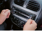 Muškarac instalira auto-radio u kontrolnu tablu automobila.