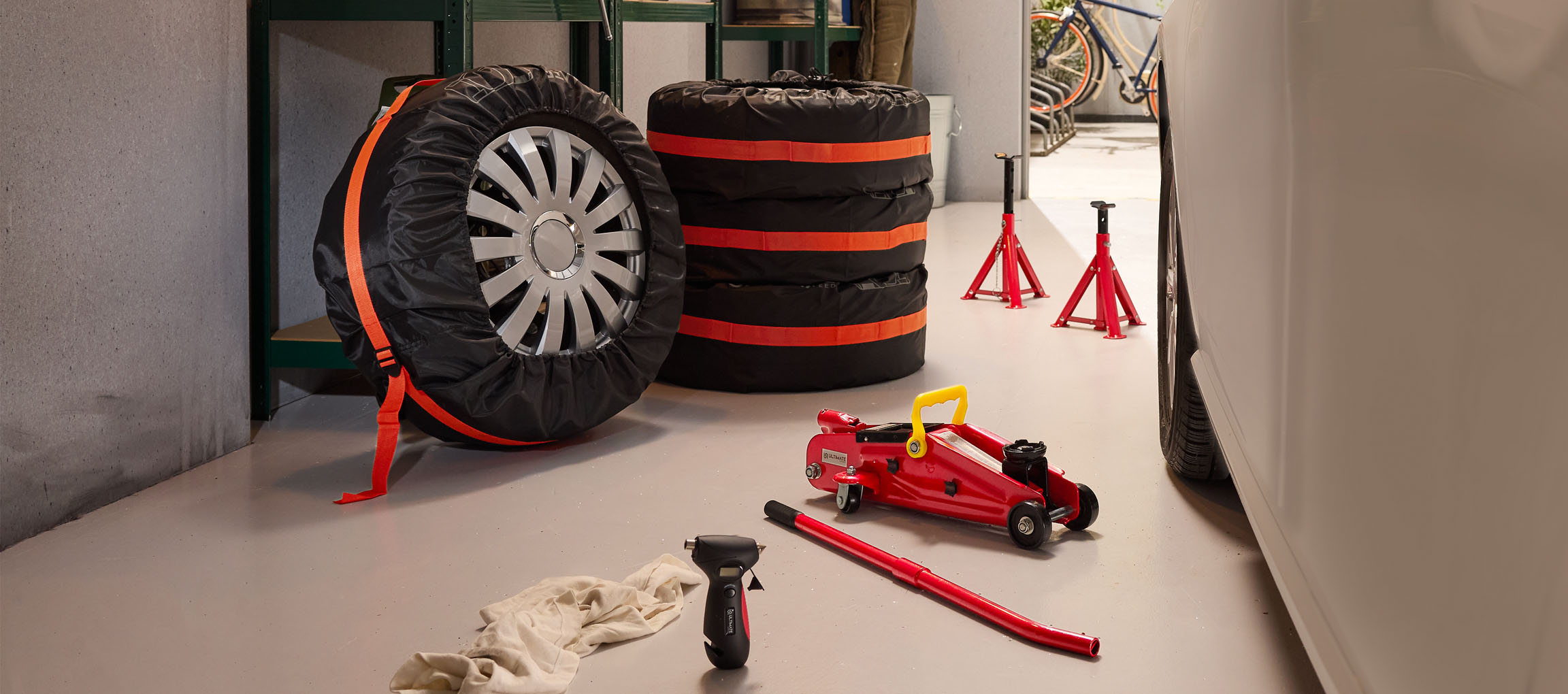 Automobilske gume sa navlakama, dizalica i stalci u garaži.