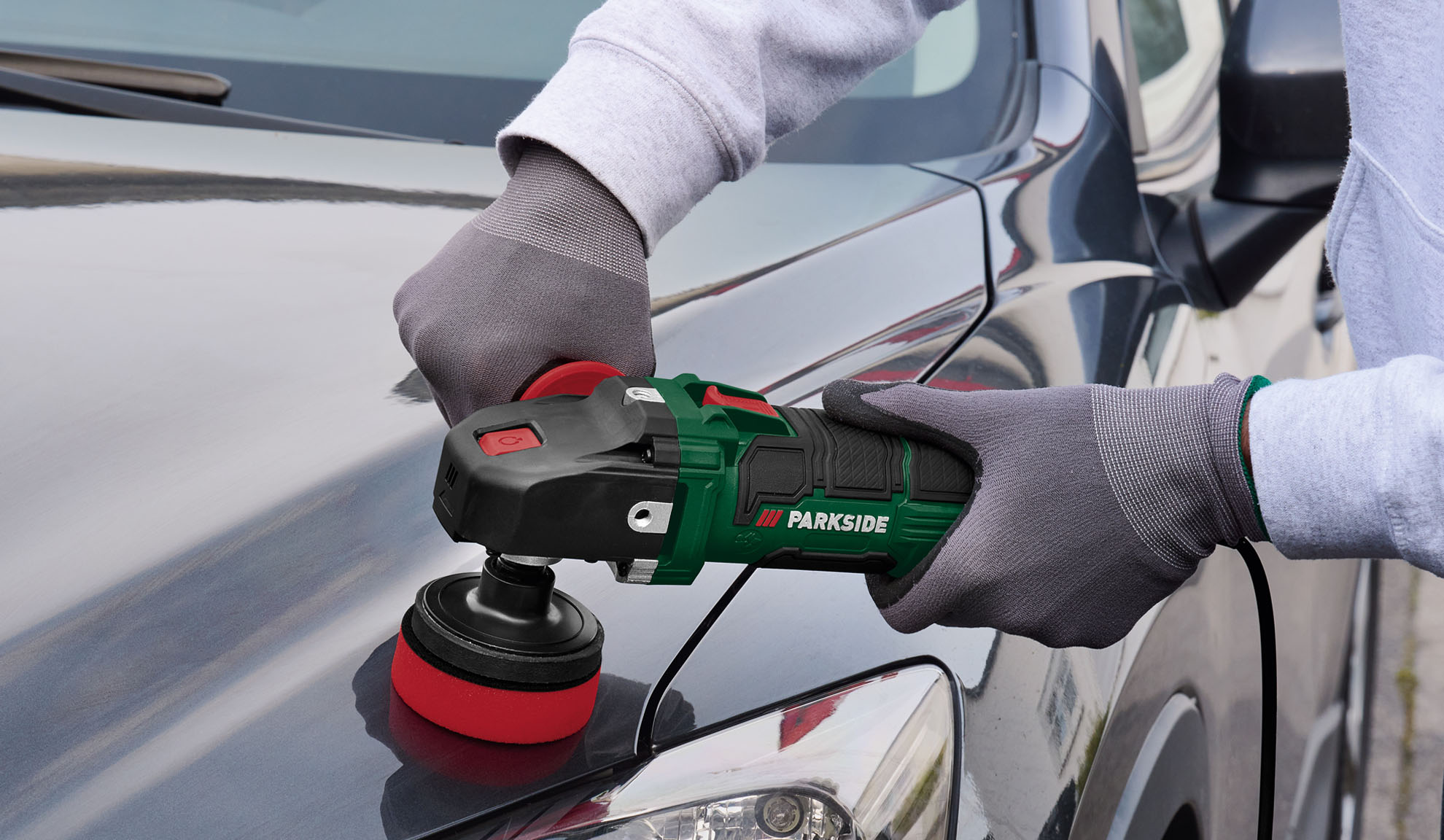 Osoba polira haubu automobila Parkside brusilicom.