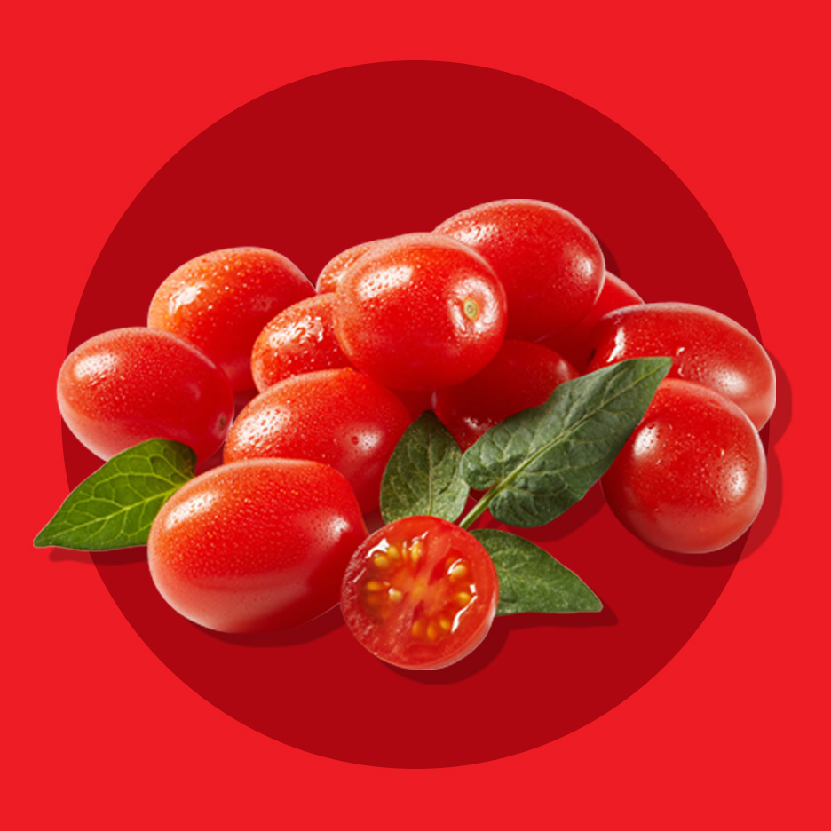 Sveži čeri paradajz sa listovima, jedan prepolovljen, na crvenoj pozadini.