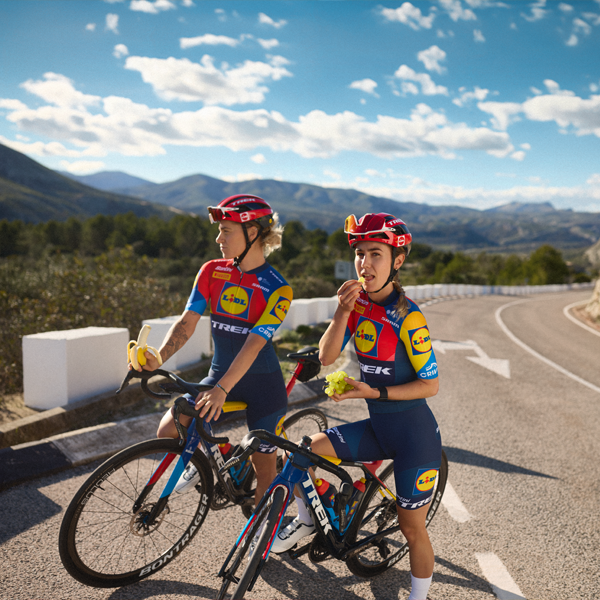 Две бициклистки из тима Trek-Segafredo Lidl уживају у паузи са воћем.