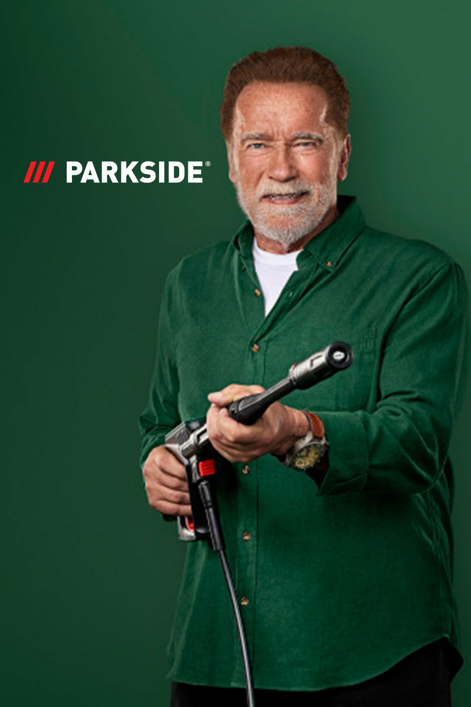 Arnold Švarceneger drži perač pod pritiskom, sa logom Parkside u pozadini.