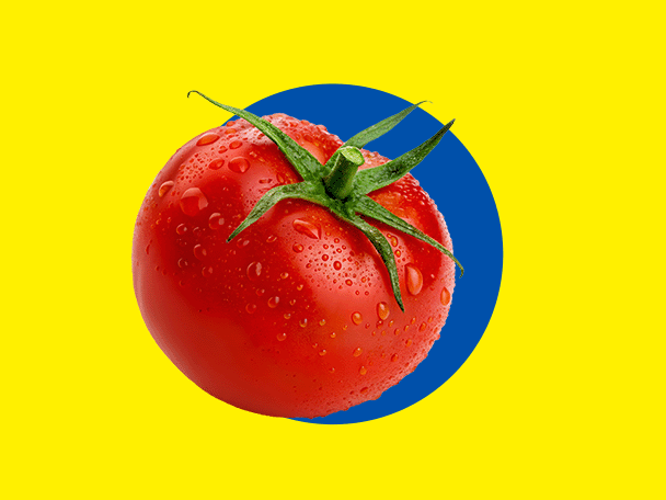 Svež crveni paradajz sa kapljicama vode, na žutoj pozadini sa plavim krugom.