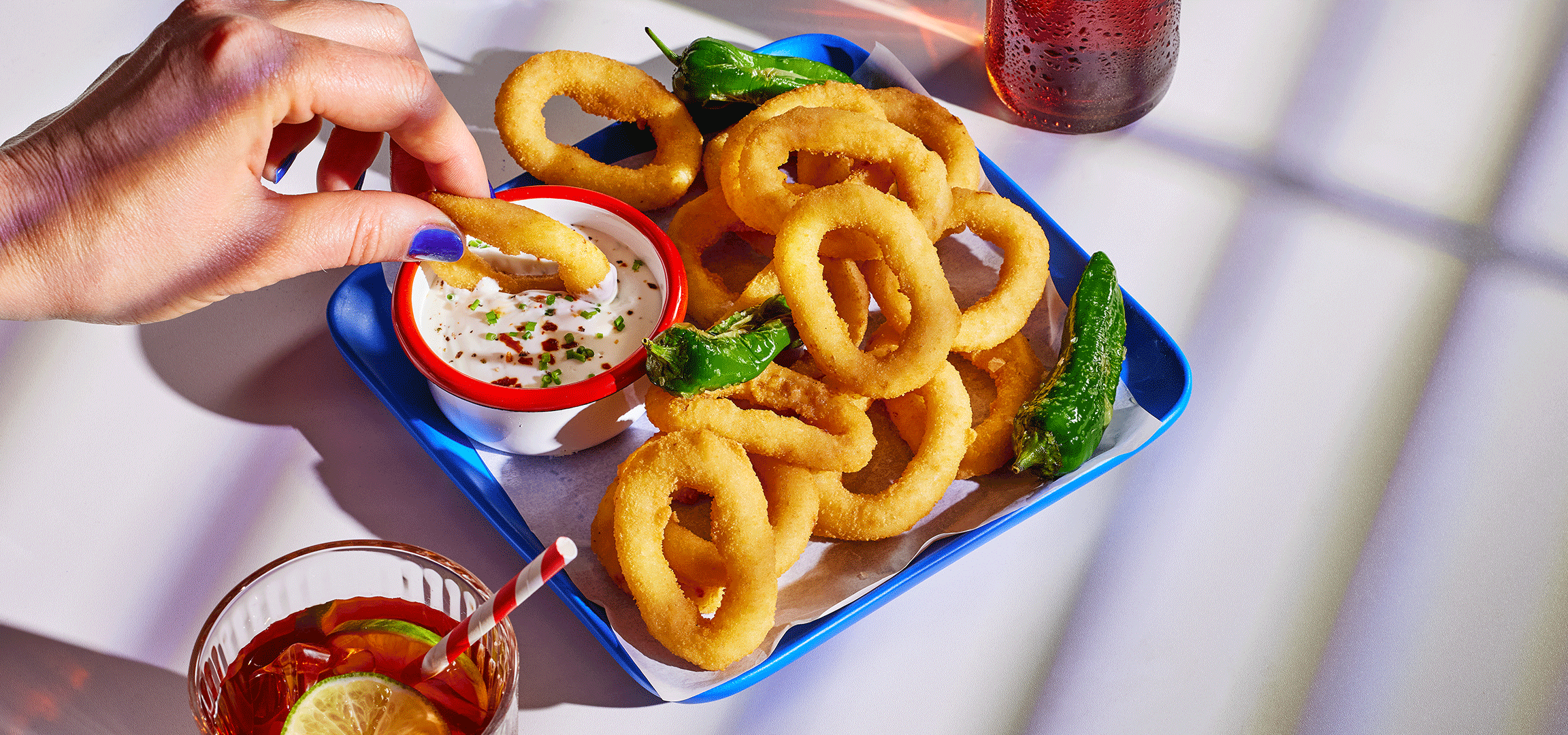 Prženi kolutići luka sa umakom, paprika i hamburger sa povrćem.