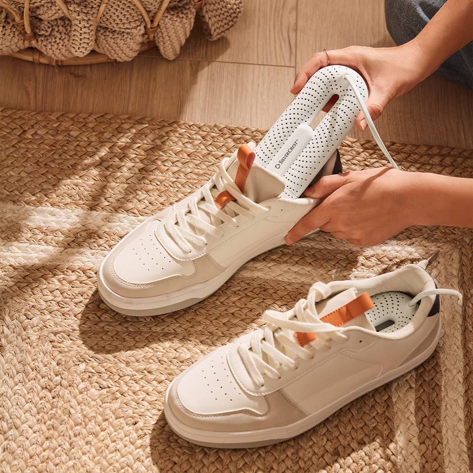 Silvercrest sušilica za cipele u belim patikama na pletenom tepihu.