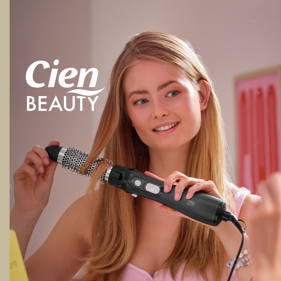Žena koristi četku za sušenje kose, sa logotipom 'BEAUTY' u gornjem levom uglu.