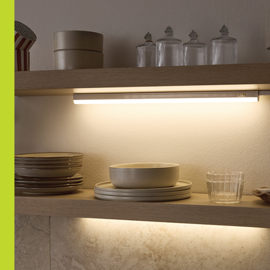 Kuhinjske police sa posuđem i LED rasvetom ispod ormarića.