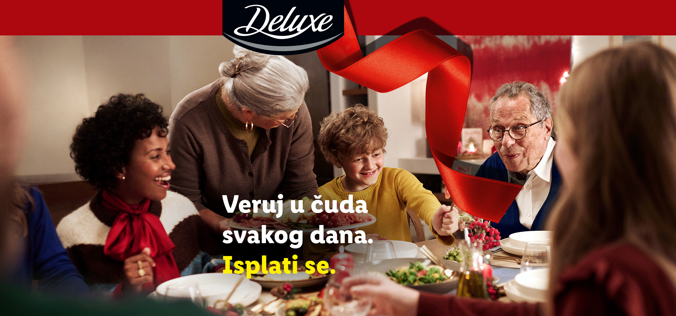 Deluxe logo, crvena traka i tekst 'Veruj u čuda svakog dana. Isplati se.' pored porodice koja uživa u Deluxe predjelu.