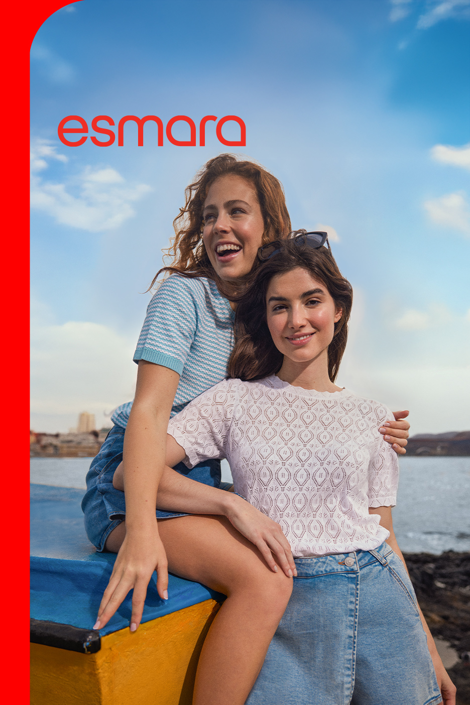 Dve žene u letnjoj odeći, džins šortsevima i pletenim majicama, sede na čamcu pored vode.