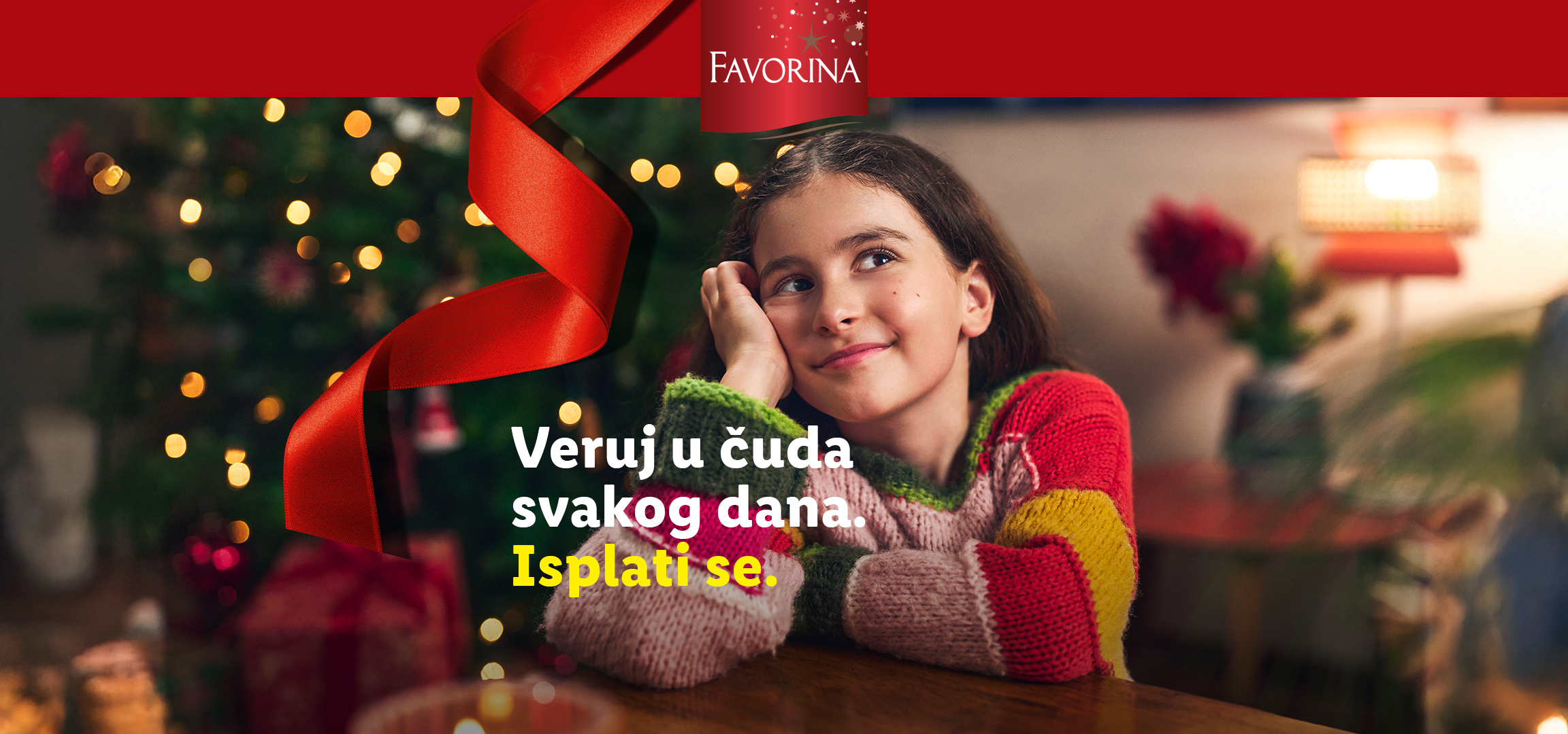 Favorina božićna dekoracija i devojčica u šarenom džemperu, sa tekstom: Veruj u čuda svakog dana. Isplati se.