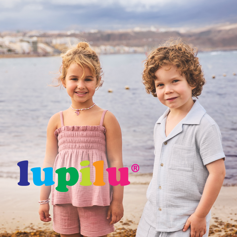 Devojčica i dečak u letnjoj odeći na plaži, sa logotipom Lupilu.