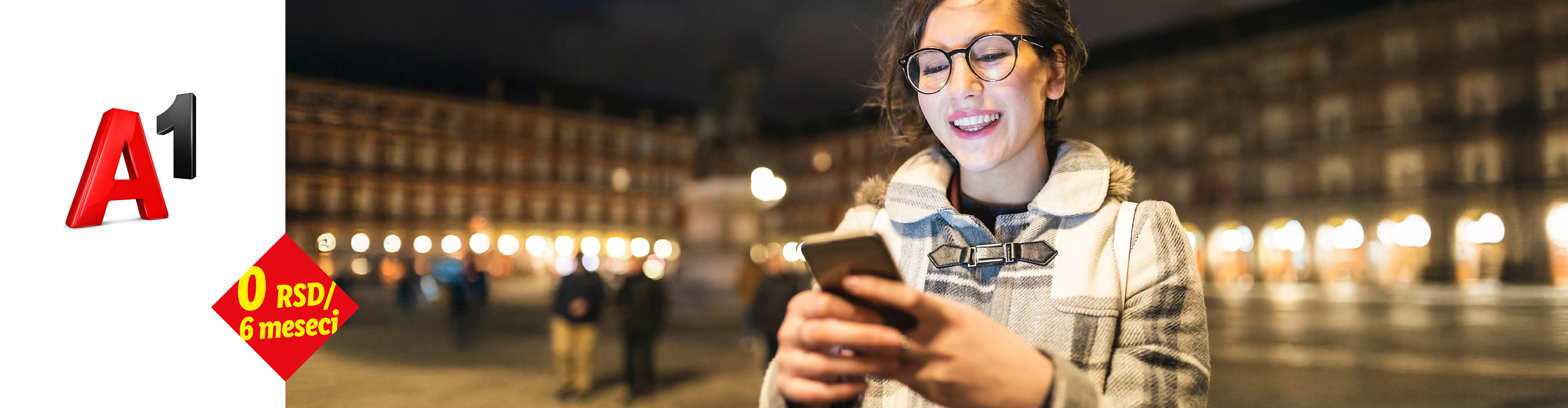 A1 promocija: 0 RSD za 6 meseci. Žena koristi mobilni telefon na noćnom trgu.