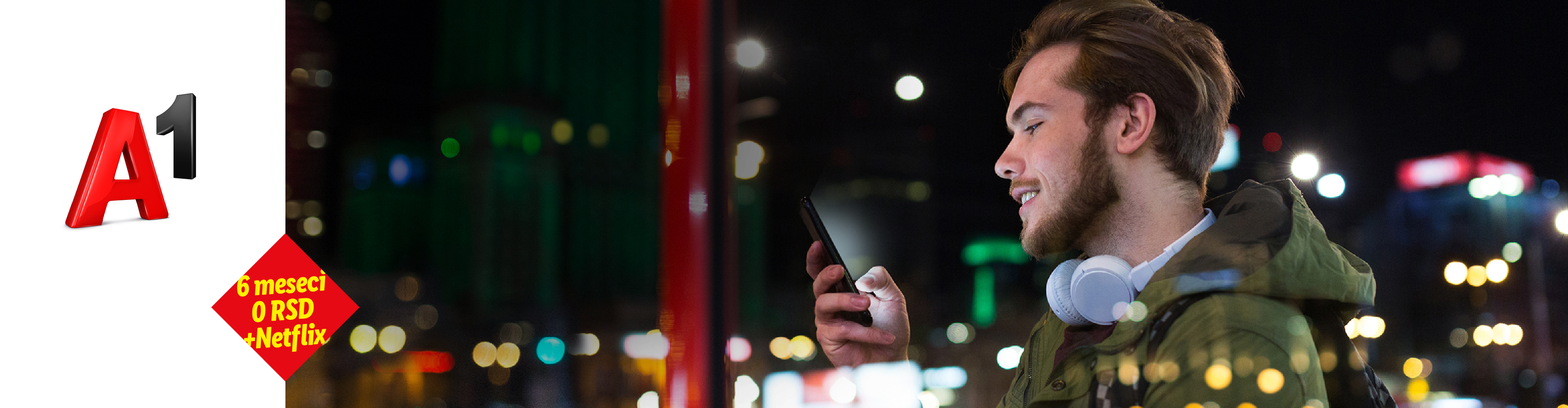 Mladić gleda u telefon, sa slušalicama oko vrata, noću u gradu, sa ponudom 6 meseci 0 RSD + Netflix.