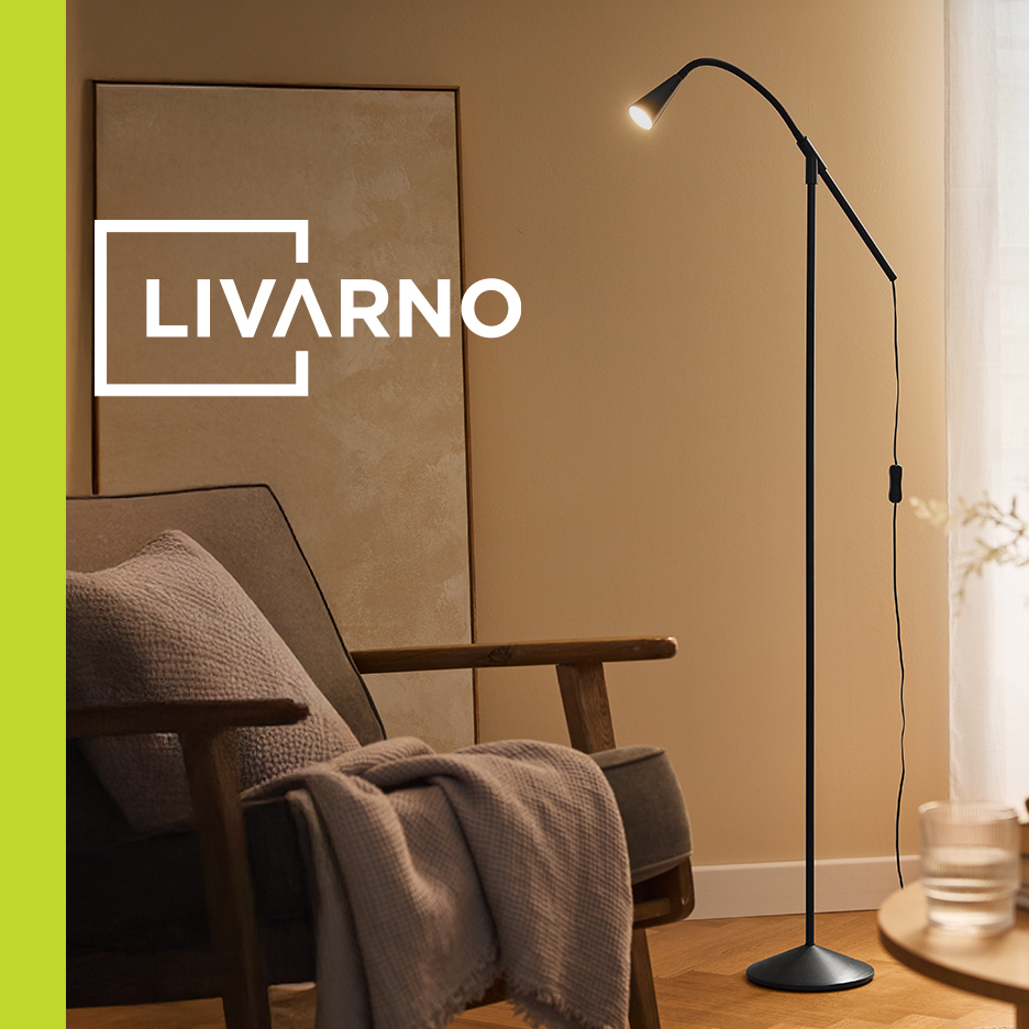 Crna podna lampa sa savitljivim vratom pored fotelje sa ćebetom, u pozadini LIVARNO logo.