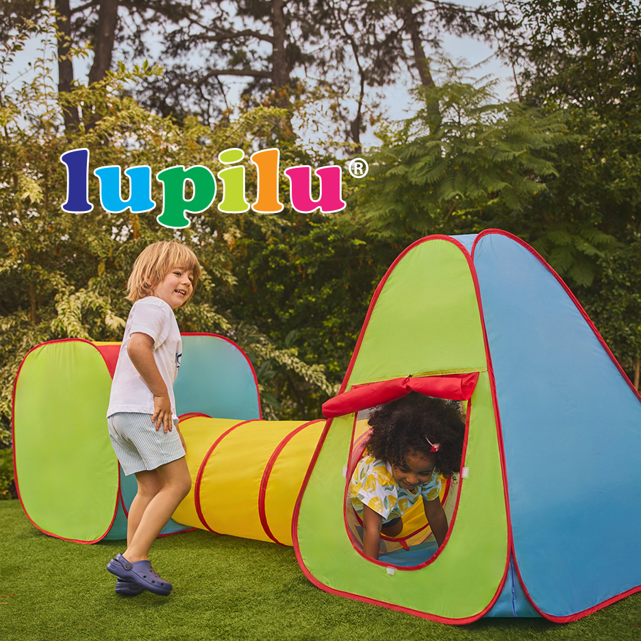 Dvoje dece se igra u šarenom tunelu i šatoru za igru na travnjaku, sa logotipom Lupilu iznad.
