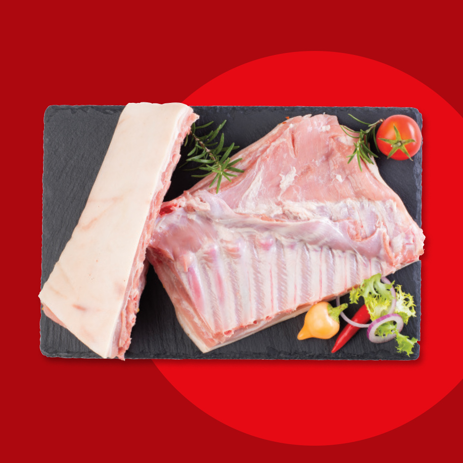 Sveža svinjska rebra i slanina na crnoj dasci sa ruzmarinom, paradajzom i čilijem.