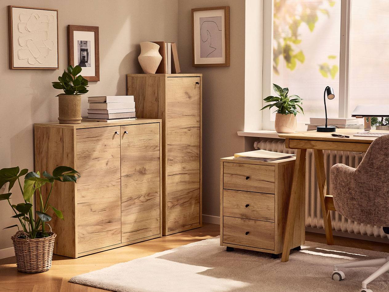 Kućna kancelarija sa svetlim drvenim ormarićima, kancelarijskom stolicom i stonom lampom.
