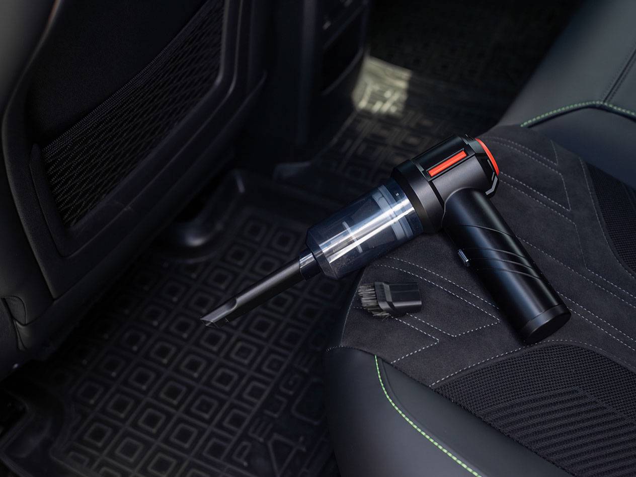 Kompaktan ručni usisivač sa dodacima na sedištu automobila.
