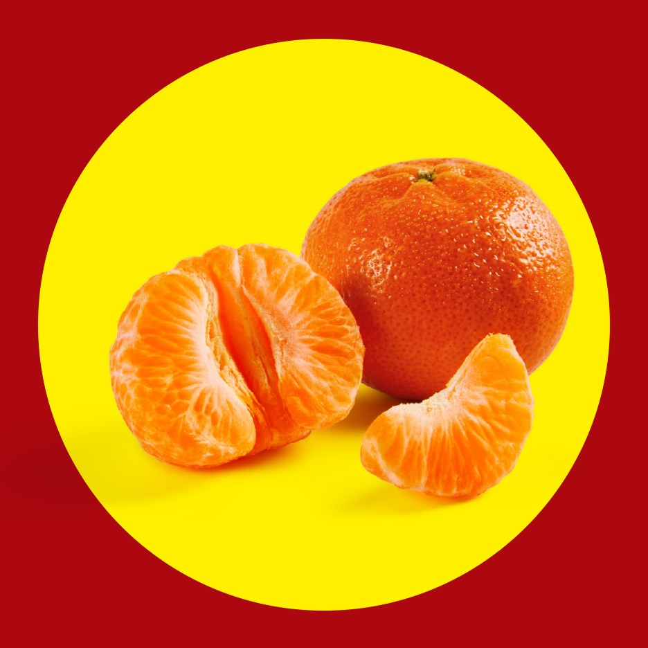 Cela i oguljena mandarina sa jednom kriškom na žutoj pozadini.