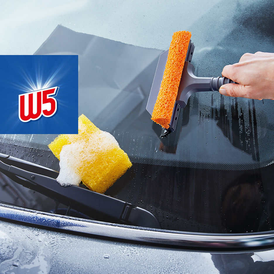 Čišćenje vetrobranskog stakla automobila sunđerom i brisačem, sa logotipom W5.