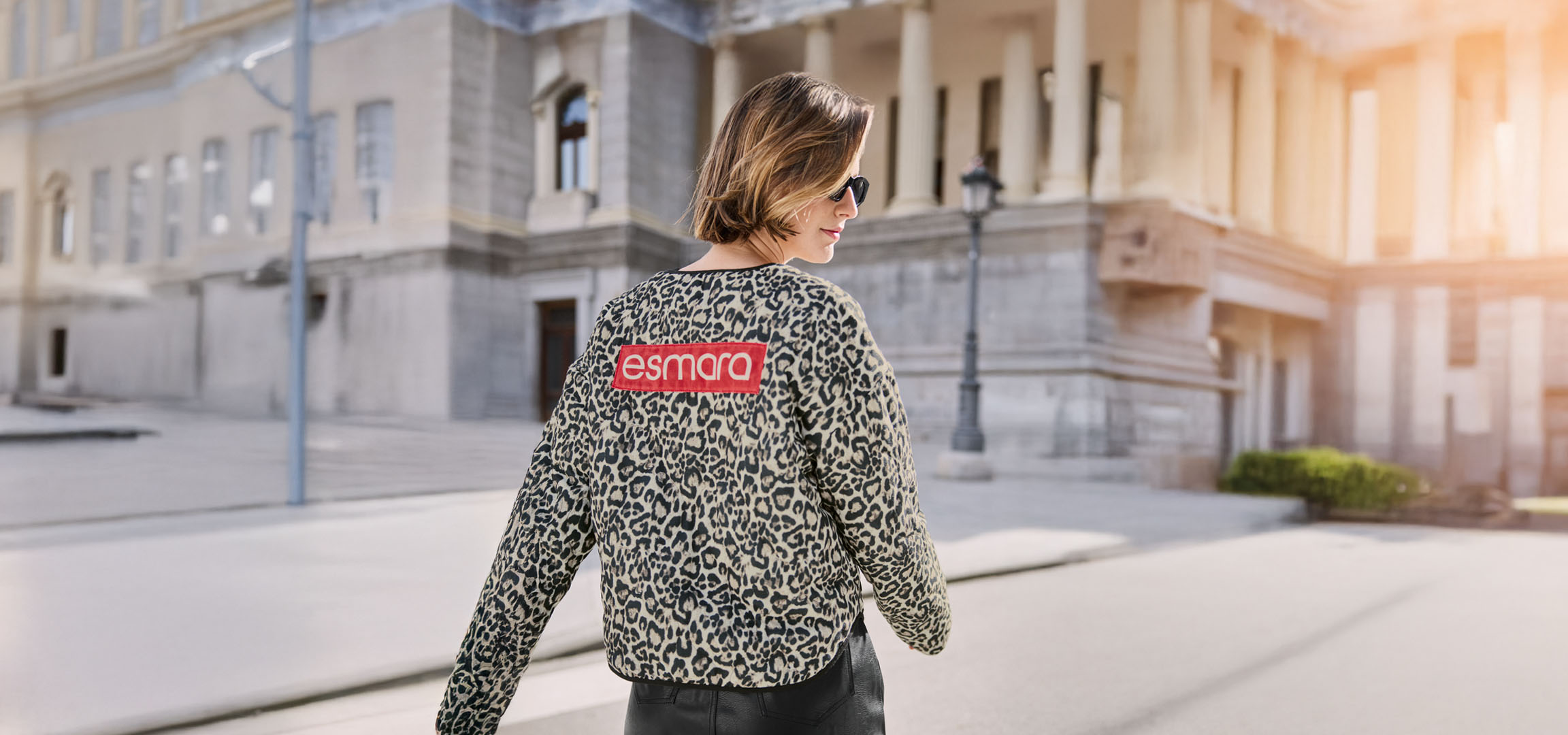 Žena u Esmara jakni sa leopard printom, naočarima za sunce, na gradskoj ulici.