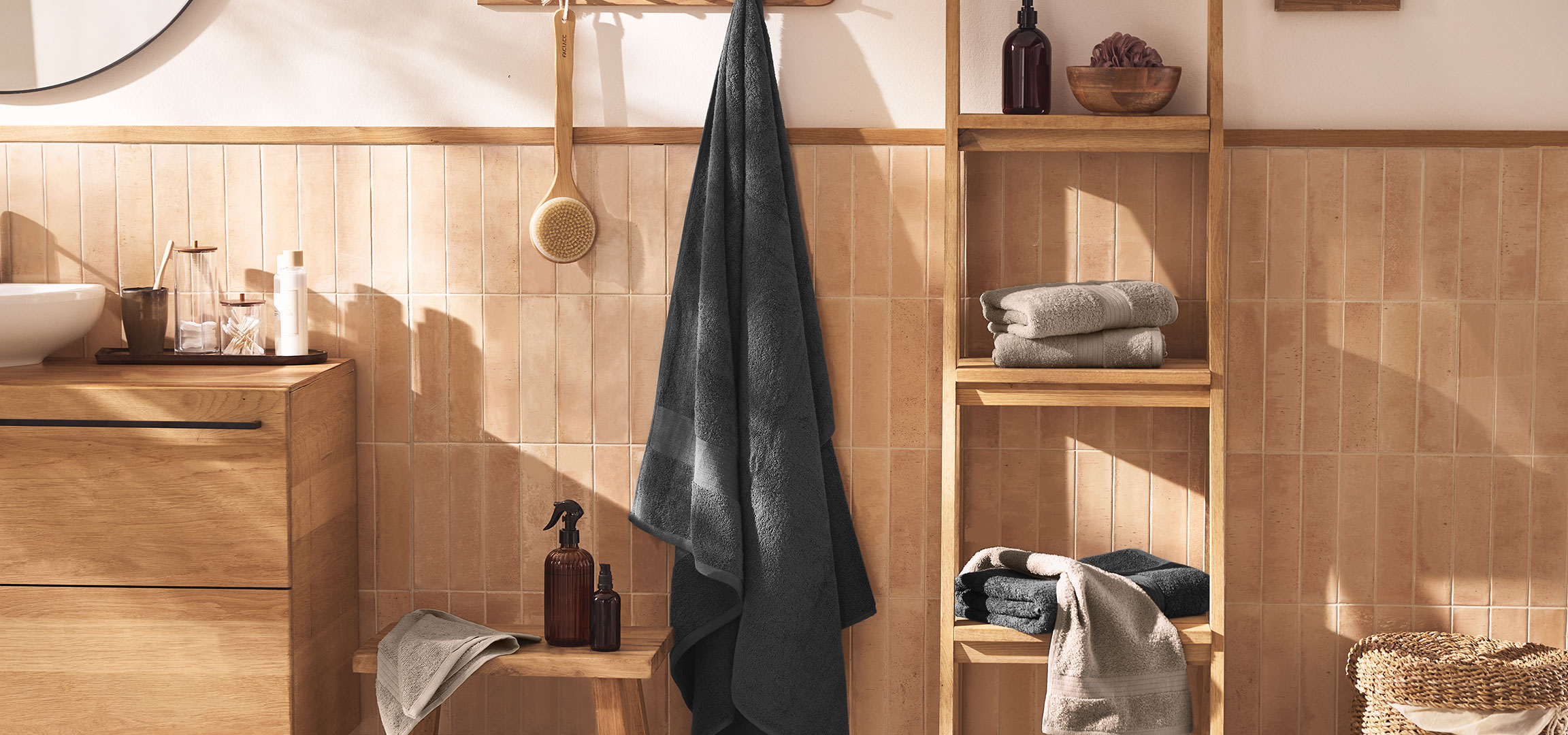 aiLabeling.aiLabelForImageAltText: Moderno kupatilo sa umivaonikom, drvenim ormarićem, peškirima i dodacima.