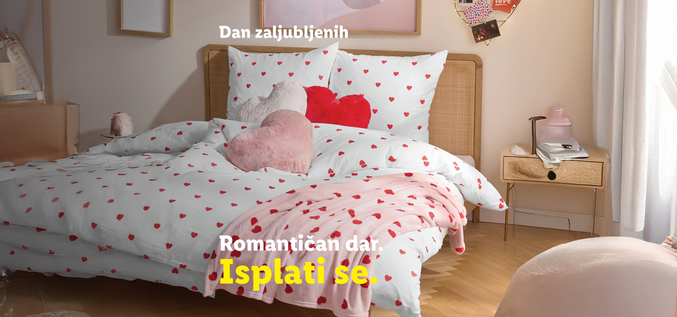 Posteljina sa srcima, ukrasni jastuci i mirisna sveća za Dan zaljubljenih.