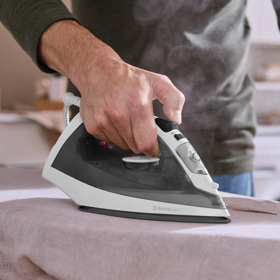 Muškarac pegla odeću SilverCrest peglom na paru.