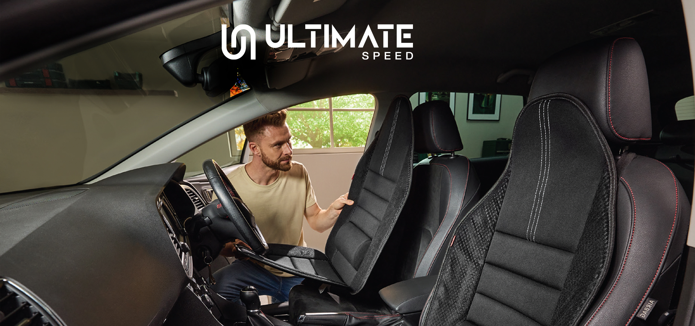 Muškarac u automobilu sa presvlakama za sedišta, organizatorima za prtljažnik i punjačem za akumulator.