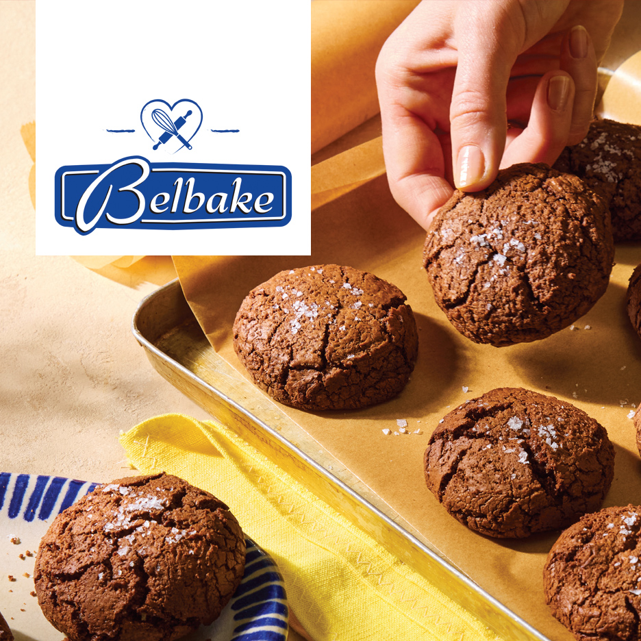 Čokoladni kolačići sa morskom solju na plehu za pečenje, ruka uzima jedan.