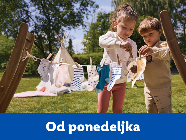 Dvoje dece kači čarape na konopac za veš u dvorištu.