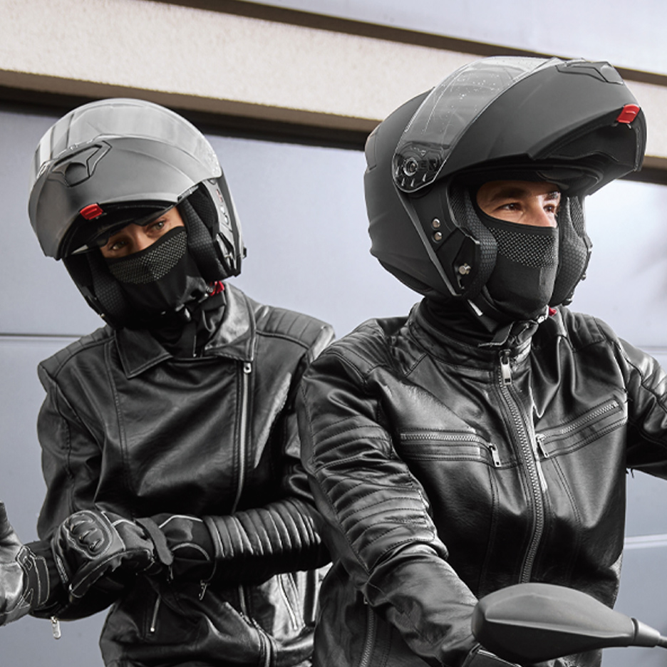 Dva motociklista u crnim kožnim jaknama i kacigama sa podignutim vizirom.