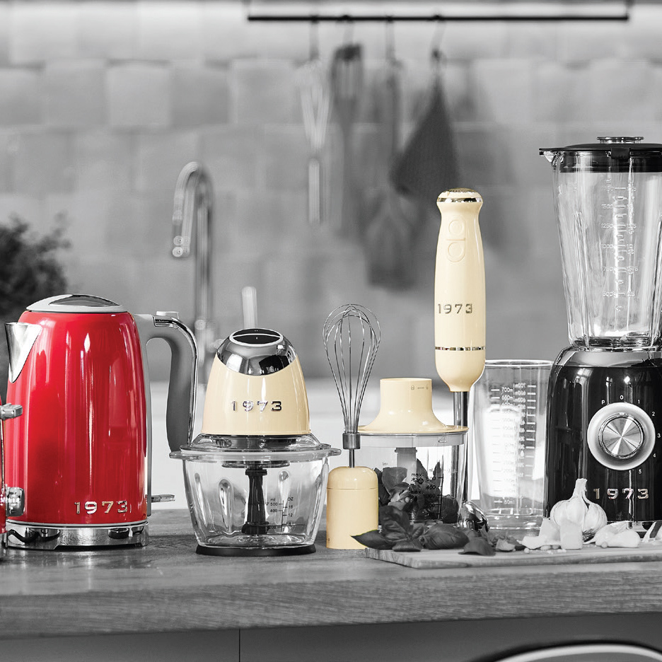 Kuhinjski aparati „1973“: crveni čajnik, bež seckalica, štapni mikser i blender na pultu.