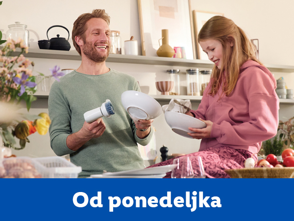 Muškarac i devojčica peru sudove u kuhinji.