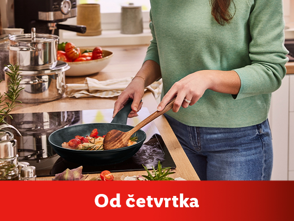 Žena kuva povrće u elegantnom zelenom tiganju.