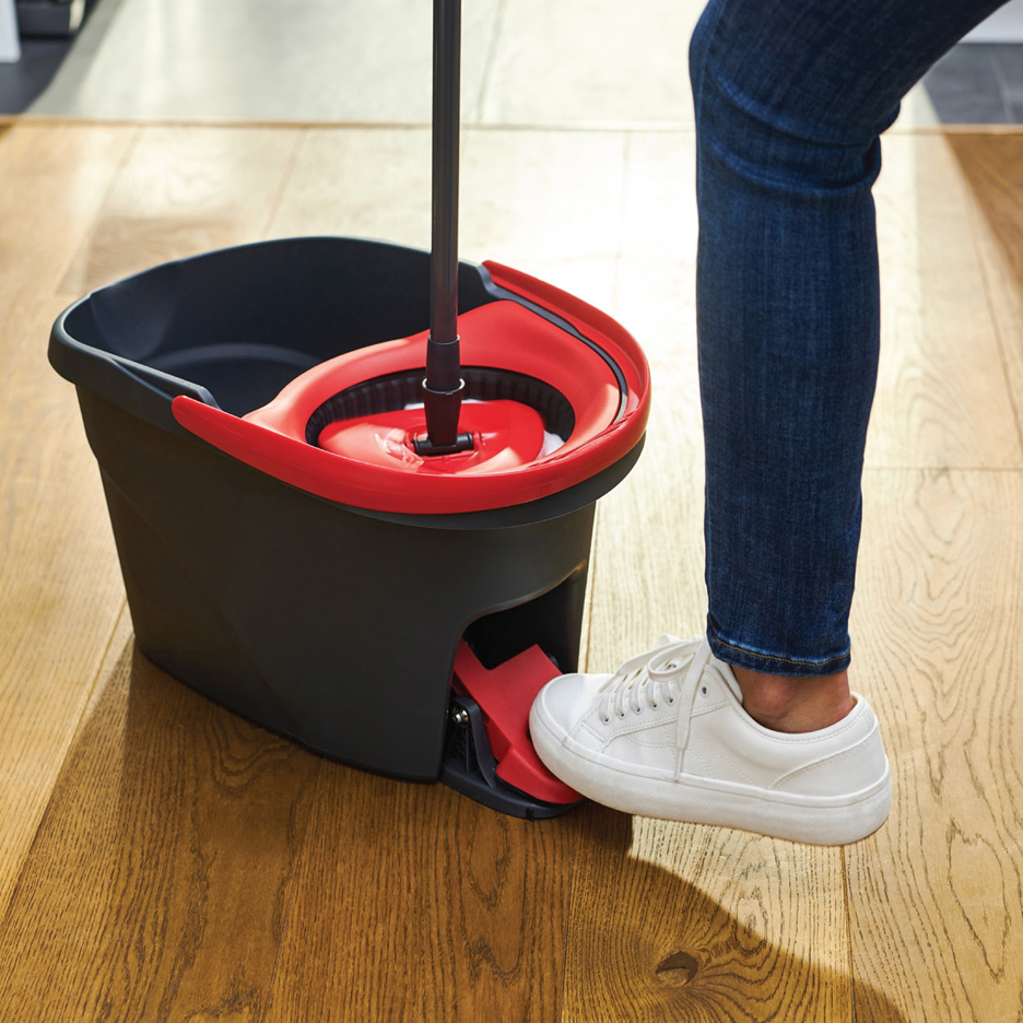 Osoba koristi kantu za brisanje sa pedalom za ceđenje.