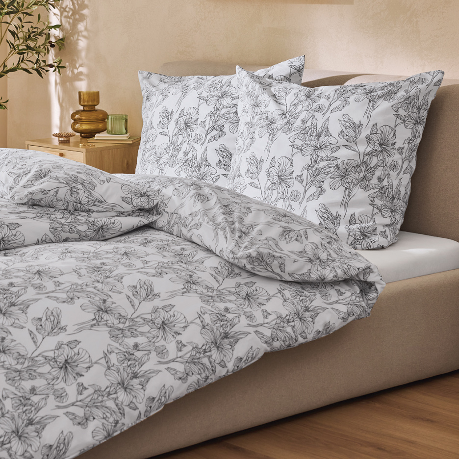 Posteljina sa cvetnim dezenom na krevetu u spavaćoj sobi.