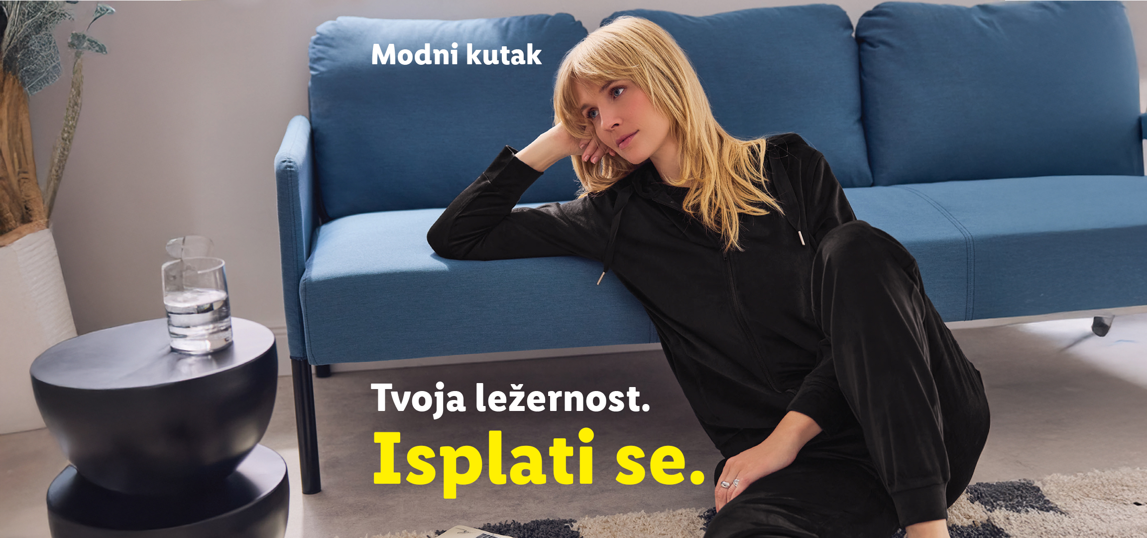 Žena u crnoj trenerci, pored nje zelena trenerka i dve majice dugih rukava.