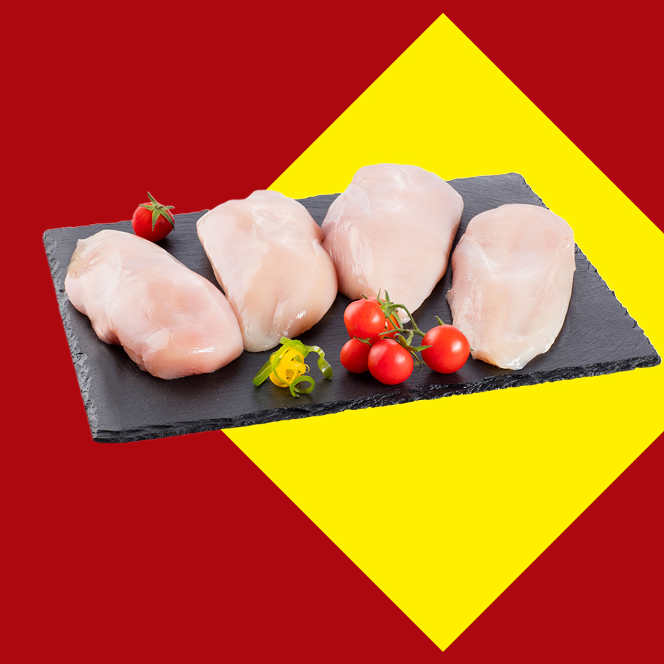 Sveža pileća prsa sa paradajzom i začinskim biljem na crnoj ploči.