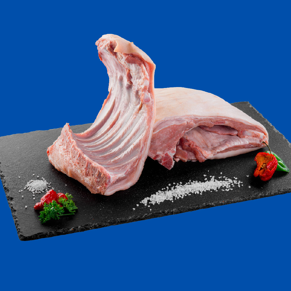 Sveža svinjska rebra i komad mesa na crnoj ploči sa solju i začinima