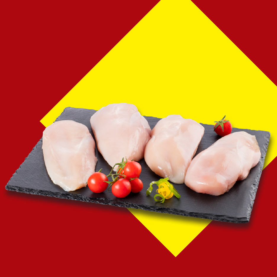 Sveža pileća prsa na crnoj ploči sa čeri paradajzom i začinskim biljem.