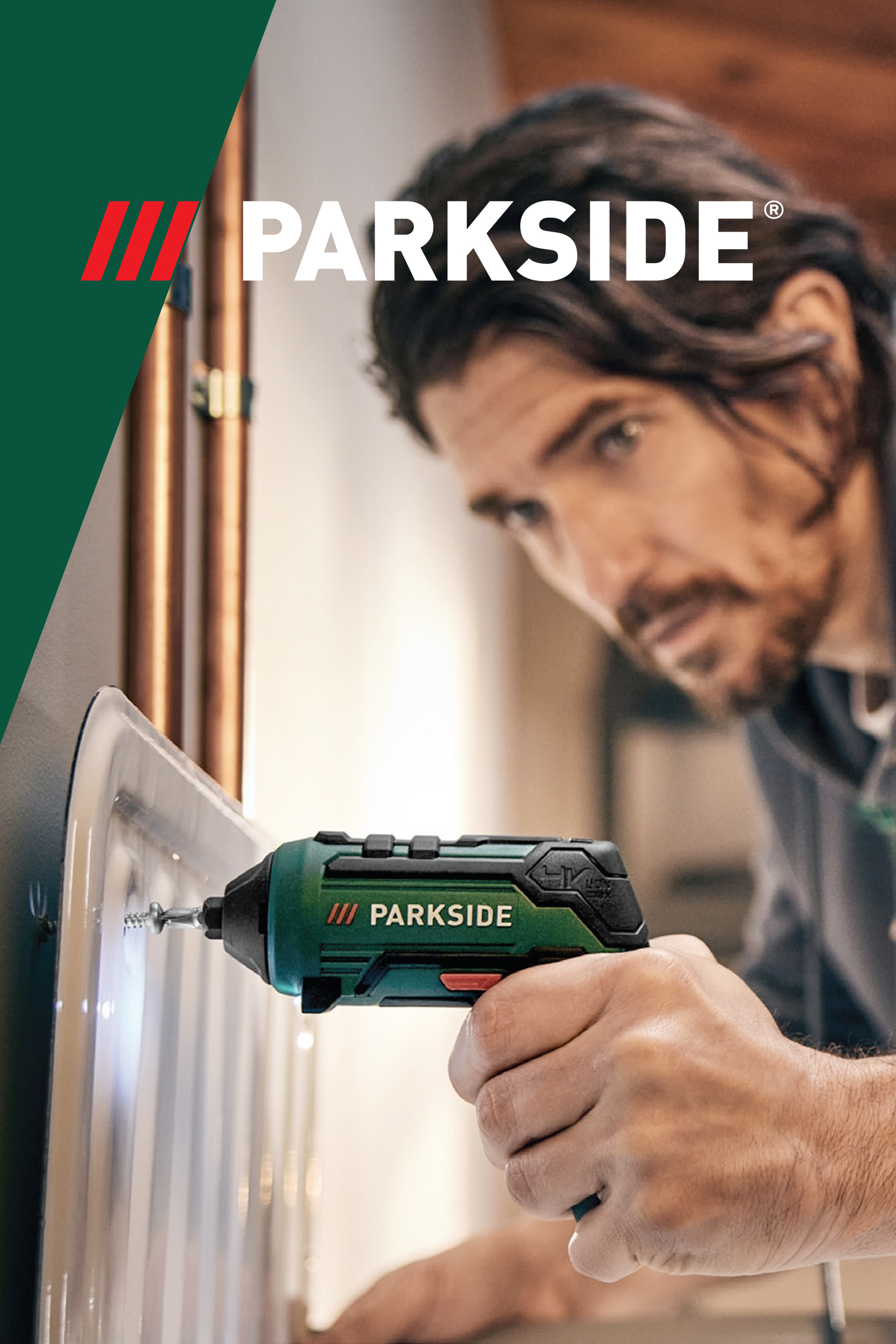 Muškarac koristi zeleni akumulatorski odvijač za zavrtanje šrafa u prozirnu ploču.